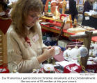 Eva Phanenhour paints birds on Christmas ornaments at the Christkindlmarkt. She was one of 59 vendors at this year's event.  [photo: Marie Zettler]