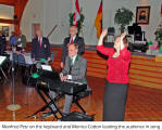 Manfred Petz on the keyboard and Monica Cotton leading the audience in song