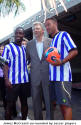 James McCreath surrounded by soccer players