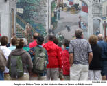 People on Notre-Dame at the historical mural listen to fiddle music [photo: Bob Sandbo]