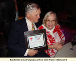 Bob Sandbo proudly displays Lucille de Saint-Andre's CEMA award